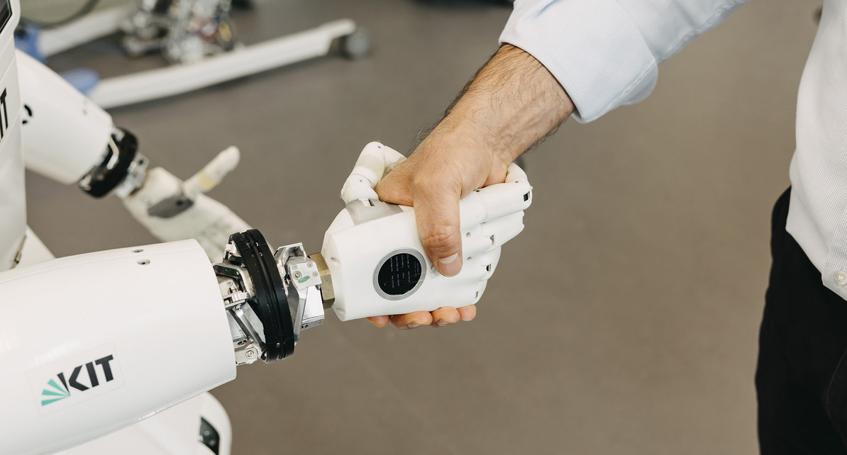 H&auml;ndesch&uuml;tteln zwischen einem Mensch und einem humanoiden Roboter im KIT.