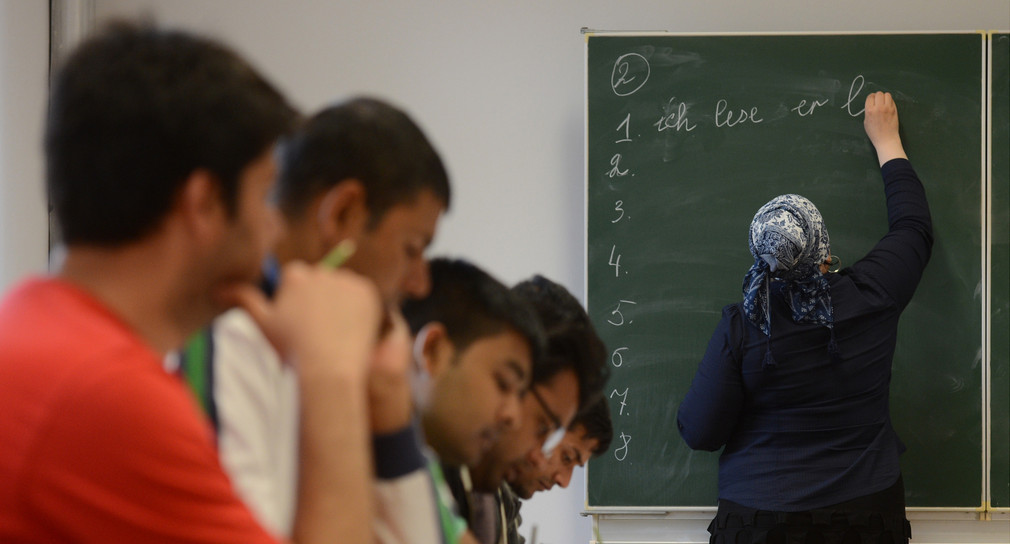 Eine Schülerin schreibt beim Deutschunterricht für Asylbewerber auf die Tafel. (Foto: © dpa)