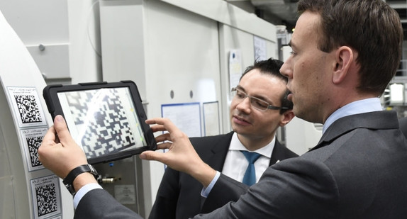 Wirtschafts- und Finanzminister Dr. Nils Schmid scannt einen 2D-Code an einer Maschine. (Foto: Wittenstein AG)