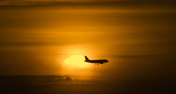 Ein Passagierflugzeug bei untergehender Sonne im Landeanflug. (Foto: dpa)