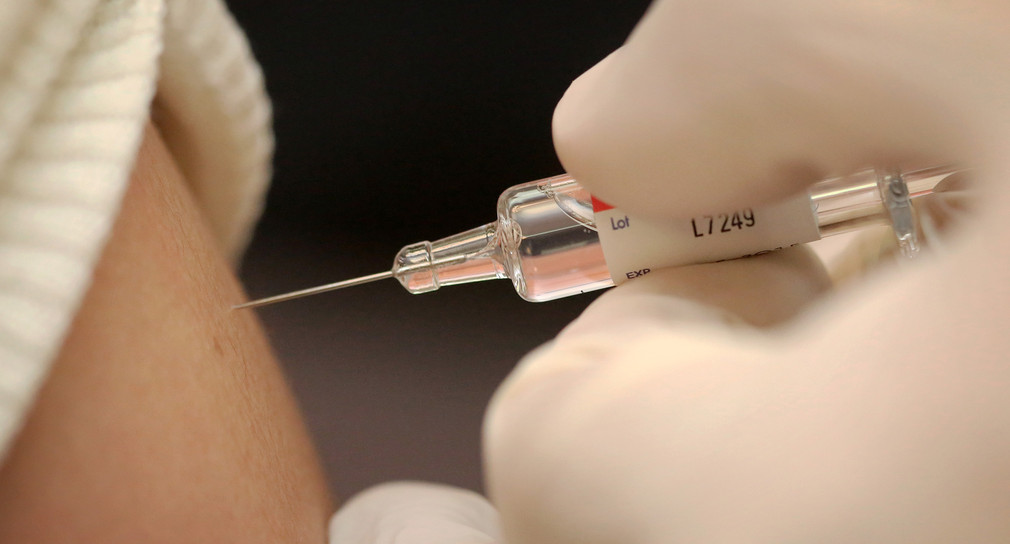 Eine Frau lässt sich gegen Grippe impfen