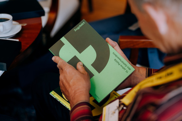 Eine Person hält eine Publikation in den Händen.