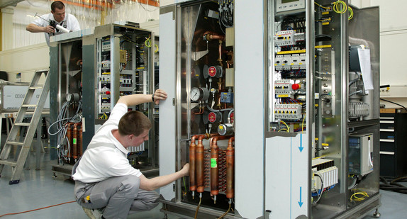 Arbeiter bauen Präzisions-Klimasysteme zusammen, die für die Lithographie-Abteilung in der Chip Produktion eingesetzt werden (Bild: © dpa).