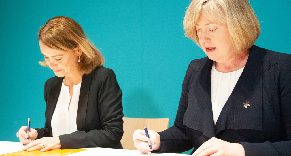 Kulturstaatssekretärin Petra Olschowski (l.), und die australische Botschafterin Lynette Wood (r.) unterschreiben ein Übergabeprotokoll (Bild: © picture alliance/Simon Sachseder/dpa)