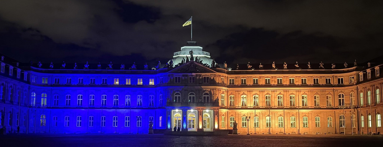 Das Neue Schloss in Stuttgart wird in den Farben gelb und blau der Flagge der Ukraine angestrahlt.