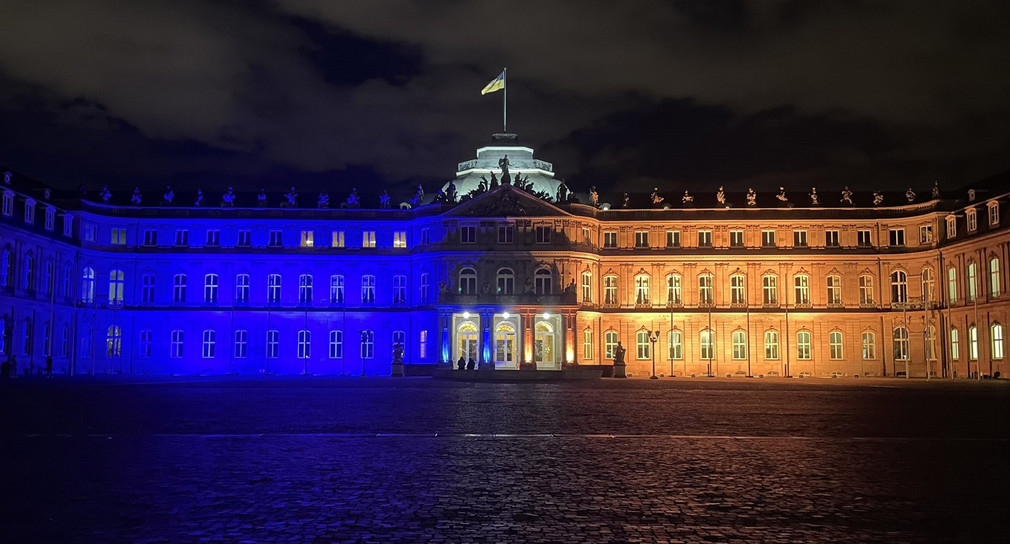 Das Neue Schloss in Stuttgart wird in den Farben gelb und blau der Flagge der Ukraine angestrahlt.