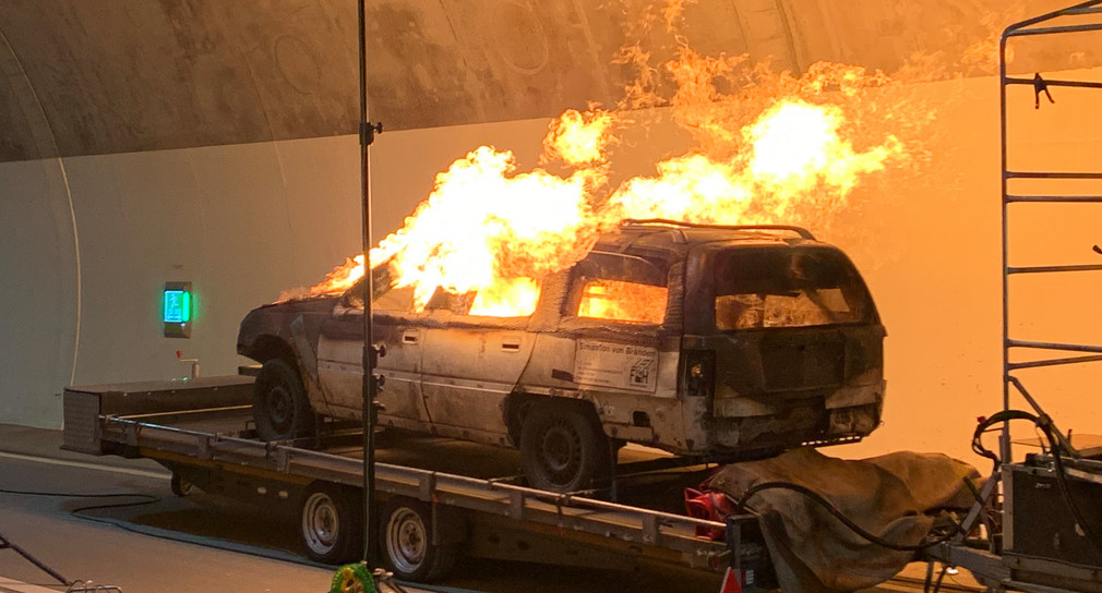 Ein Auto wird bei einem Brandversuch in einem Tunnel in Brand gesetzt.