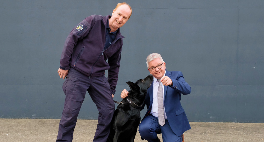 Diensthundelehrwart Roman Schnetz (l.) und Justizminister Guido Wolf (r.) mit dem Betäubungsmittelspürhund Coco