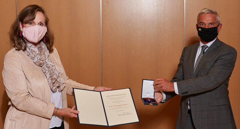 Innenminister Thomas Strobl (r.) überreicht Monica Wüllner (l.) das Bundesverdienstkreuz am Bande
