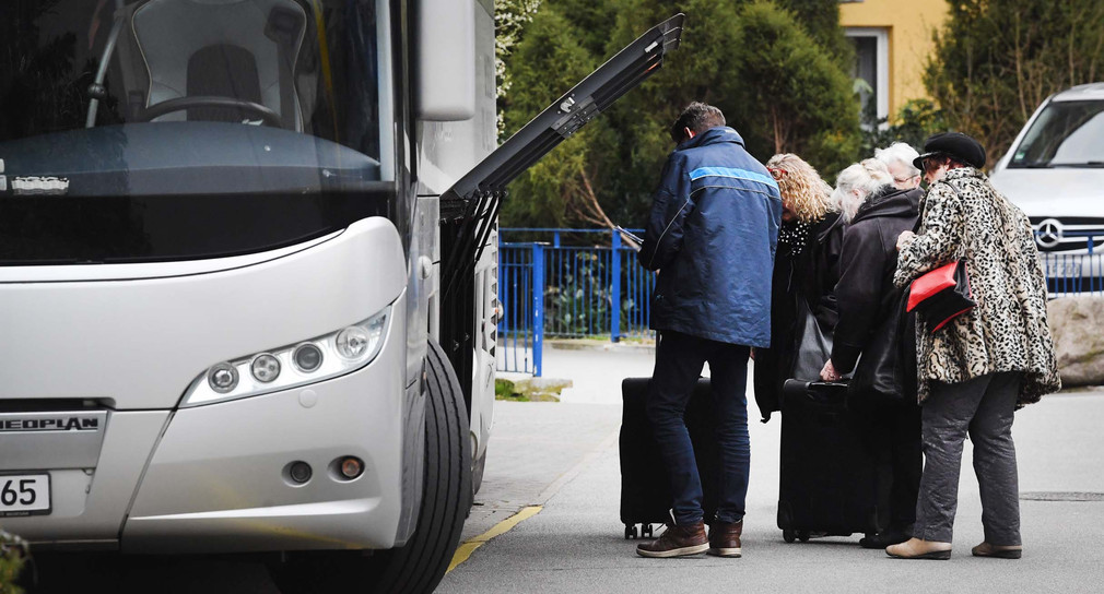 Touristen stehen an einem Reisebus (Bild: © picture alliance/Stefan Sauer/dpa-Zentralbild/dpa)