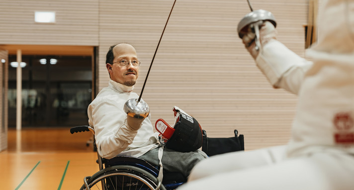 Zwei Rollstuhlfahrer fechten gegeneinander.
