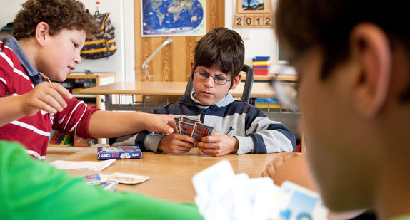 Schüler in Inklusionsklasse spielen Karten