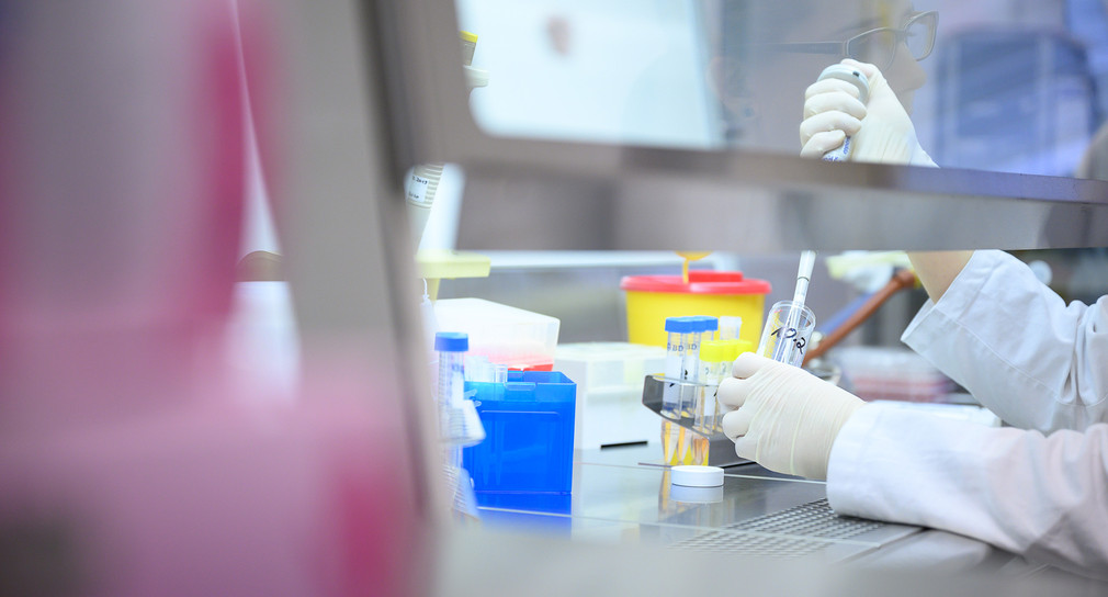 Frau in einem Labor zeigt Test für das neue Coronavirus