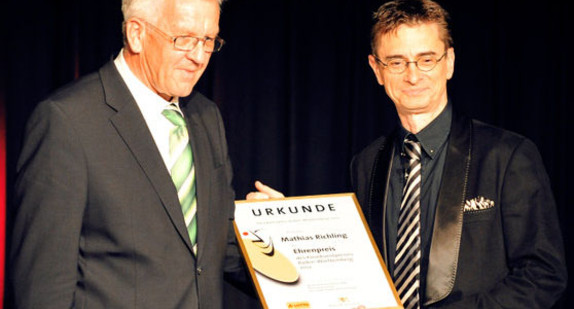 Ministerpräsident Winfried Kretschmann (l.) ehrt Kabarettist Mathias Richling (r.) am Donnerstag (24.05.2012) auf der Kleinkunstbühne Rosenau in Stuttgart. (Foto: dpa)