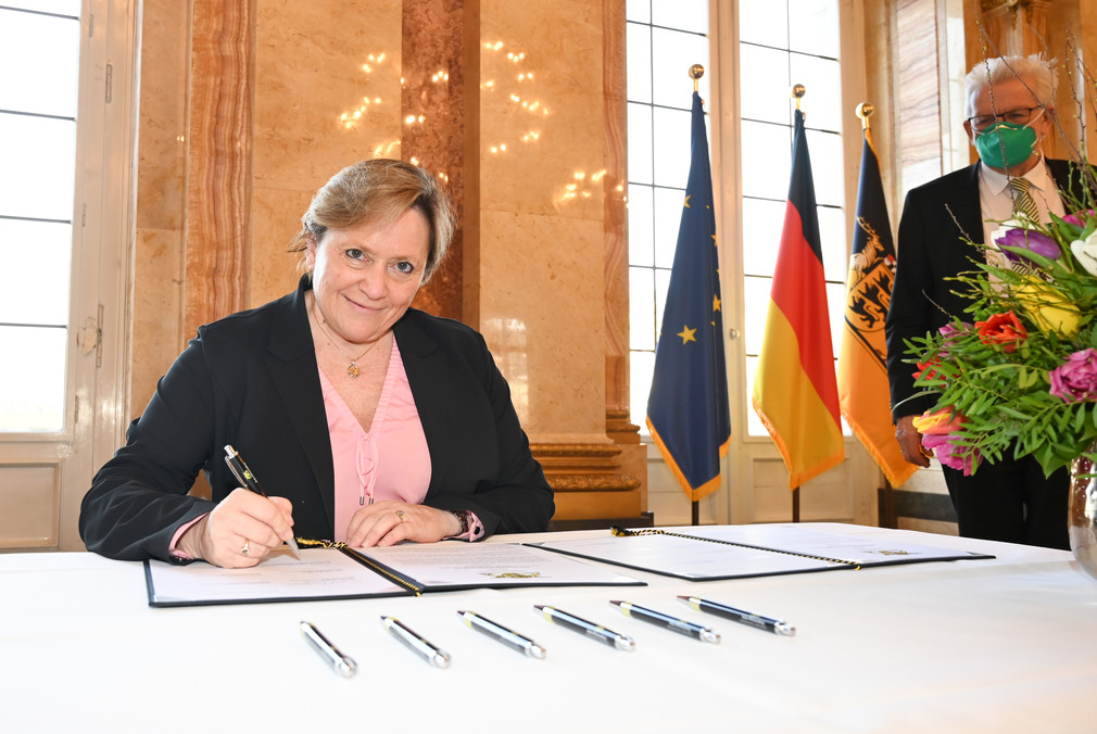Sportministerin Dr. Susanne Eisenmann (l.) bei der Unterzeichnung des Solidarpakts Sport IV, daneben steht Ministerpräsident Winfried Kretschmann (r.).