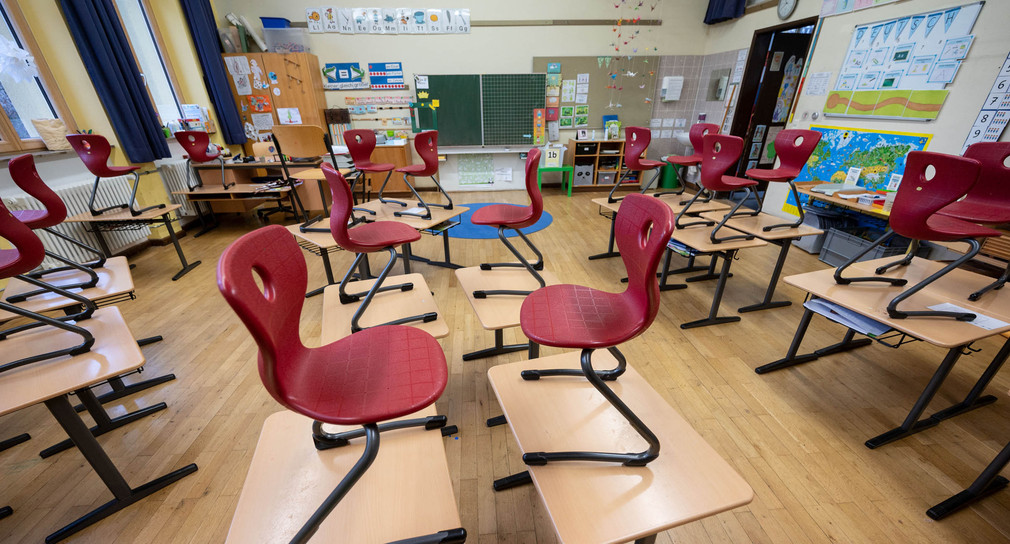 Stühle stehen in einem Klassenzimmer einer Grundschule auf Tischen.