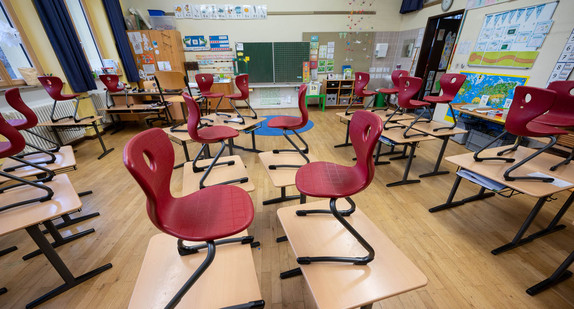 Stühle stehen in einem Klassenzimmer einer Grundschule auf Tischen.