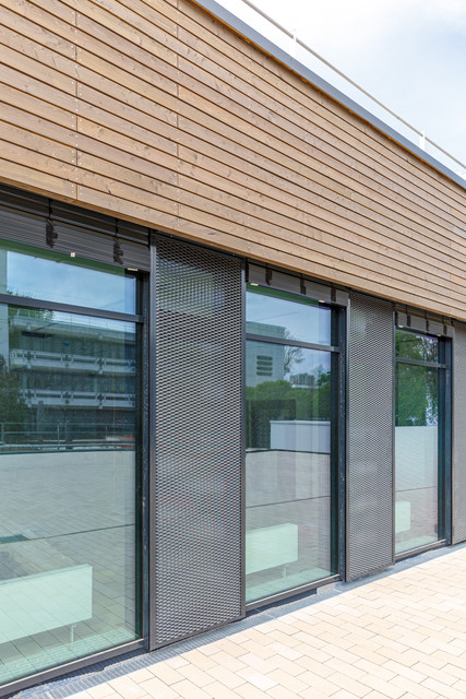 Blick auf die mit Streckmetall verschatteten Fenster der Ostseite auf der Dachterras-se