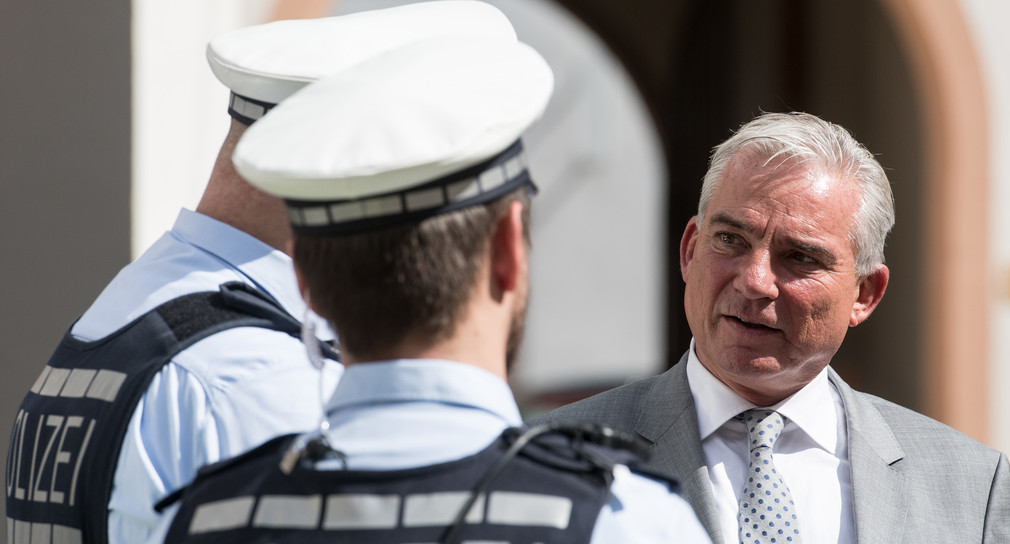 Innenminister Thomas Strobl spricht mit Polizisten (Bild: © dpa)