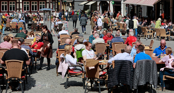 Touristen sitzen im Aussenbereich von Restaurants.