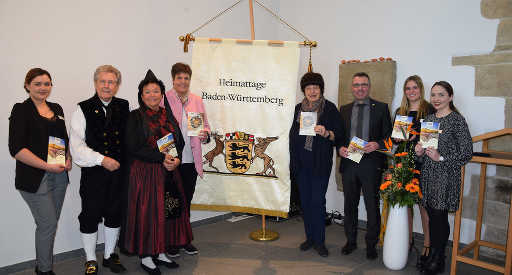 Gruppenbild mit Staatsrätin Gisela Erler (4.v.r.), Regierungspräsidentin Sylvia M. Felder (4.v.l.), Sinsheims Oberbürgermeister Jörg Albrecht (3.v.r.), Ines Kern (2.v.r.), Leiterin der Geschäftsstelle Heimattage in Sinsheim, sowie dem Sinsheimer Trachtenpaar Richard und Monika Spranz (2. und 3.v.l.) (Bild: Stadt Sinsheim)