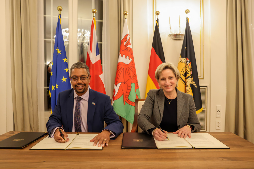 Wirtschaftsministerin Dr. Nicole Hoffmeister-Kraut (rechts) und der walisische Wirtschaftsminister Vaughan Gething (links) bei der Unterzeichnung einer gemeinsamen Erklärung zur Zusammenarbeit zwischen Baden-Württemberg und Wales.