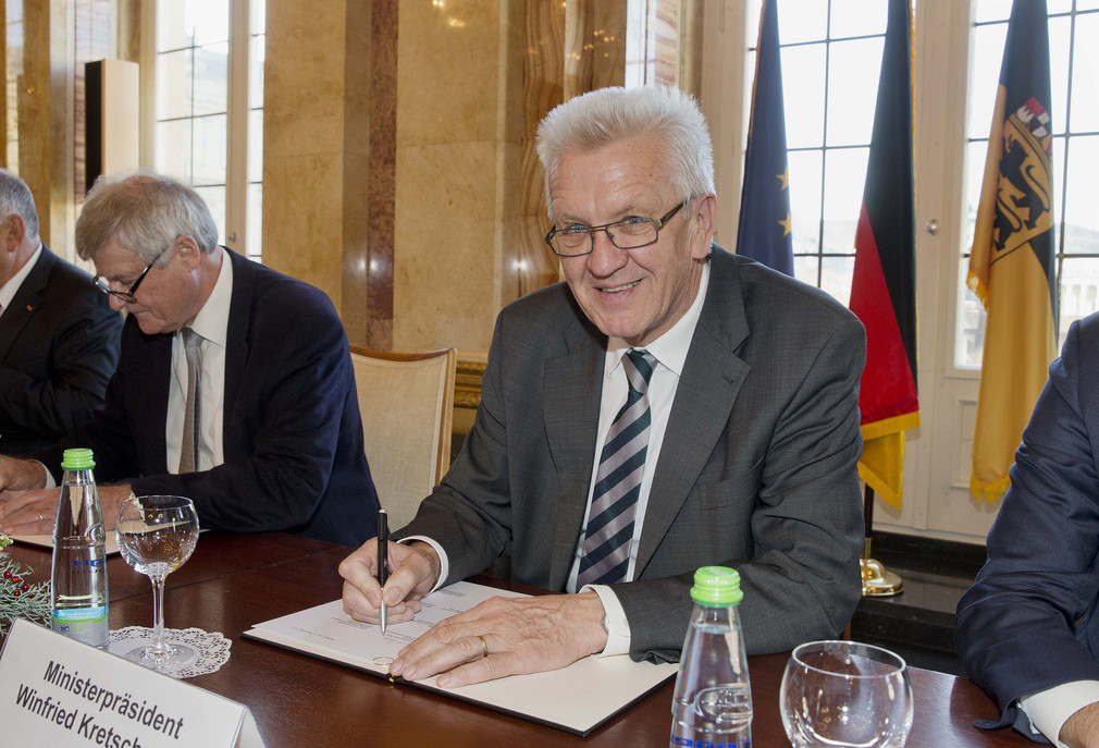 Ministerpräsident Winfried Kretschmann beim Unterzeichnen des Solidarpakts.