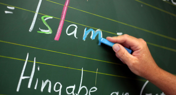 Ein Religionslehrer schreibt im Islamunterricht an die Tafel (Foto: dpa)