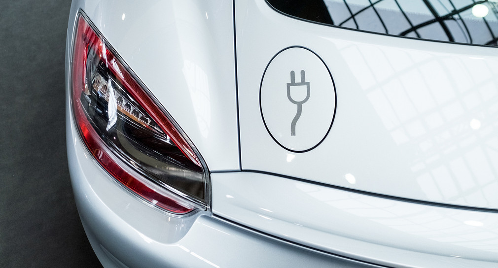 Ein Stecker-Symbol ist an einem Stand des Stuttgarter Sportwagenherstellers Porsche bei der Hannover Messe auf der Tankklappe eines Elektro-Porsche Turbo zu sehen. (Bild: Ole Spata / dpa)