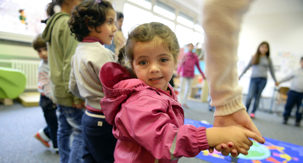 Ein Flüchtlingskind aus Syrien spielt in einem Kindergarten (Bild: © dpa).