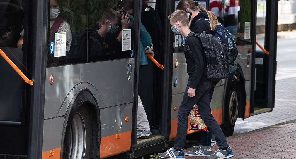 Schüler steigen in einen Bus (Bild: © picture alliance/Swen Pförtner/dpa)