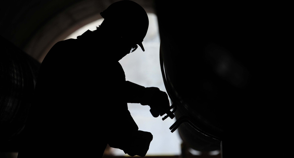 Symbolbild: Ein Mitarbeiter kontrolliert energietechnische Versorgungsrohre. (Bild: Hannibal Hanschke / dpa)  