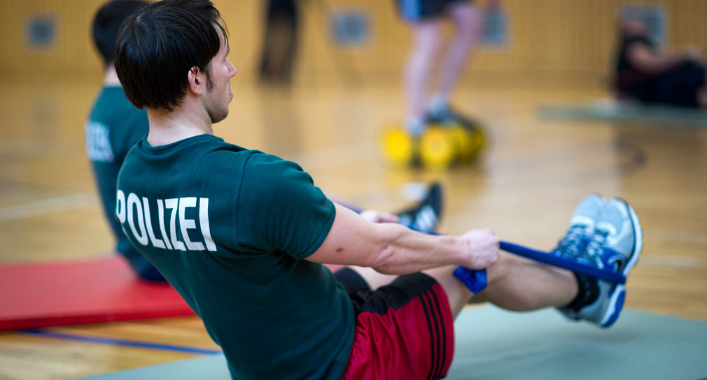 Ein Polizeibeamte trainiert in einer Sporthalle im Zirkeltraining die Stärkung der Tiefenmuskulatur. (Foto: © dpa)