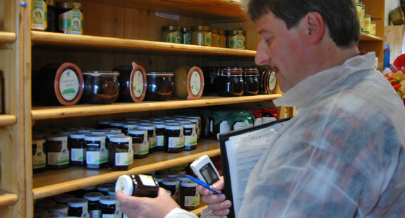 Ein staatlicher Lebensmittelkontrolleur überprüft das Mindesthaltbarkeitsdatum eines Produktes.
