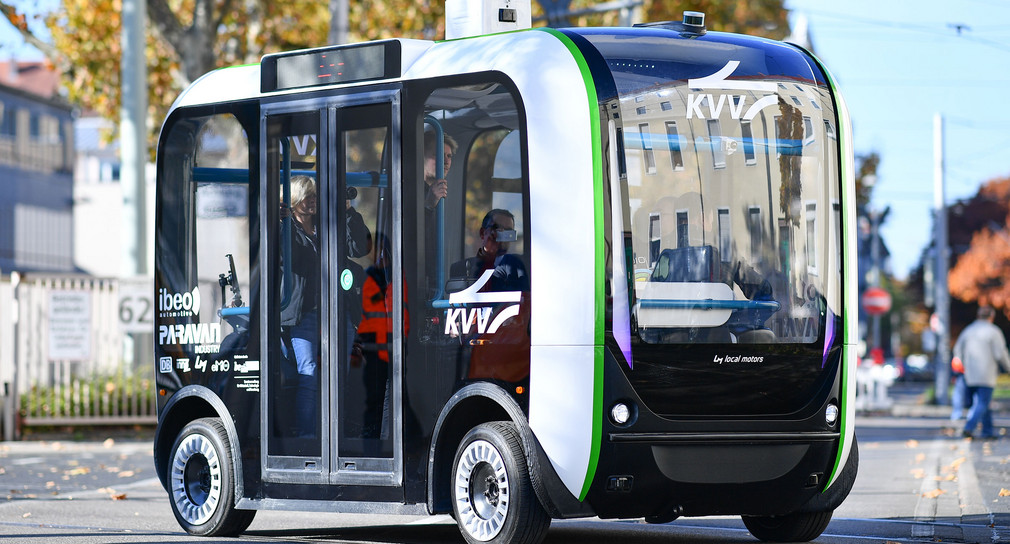 Ein autonom fahrender Elektro-Mini-Omnibus überquert vor dem Gebäude des Karlsruher Verkehrsverbunds eine Straße. (Foto: © dpa)