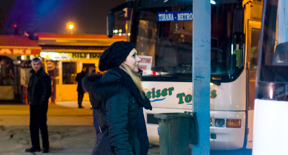 Eine Frau am Busbahnhof in Priština (Symbolbild: © dpa).