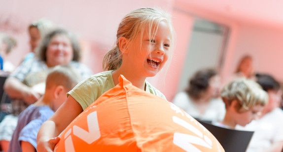 Auf der Preisverleihung des Wettbewerbs "Kleine Helden setzen Zeichen": Mädchen spielt mit dem Würfel der Nachhaltigkeitsstrategie (Foto: UM/Martin Stollberg)