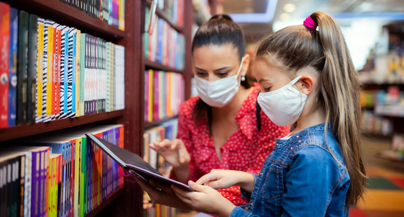 Eine Mutter ist mit ihrer Tochter in einer Buchhandlung.