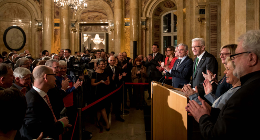 Ministerpräsident Winfried Kretschmann (r.) spricht beim Neujahrsempfang der Landesregierung zu den Gästen