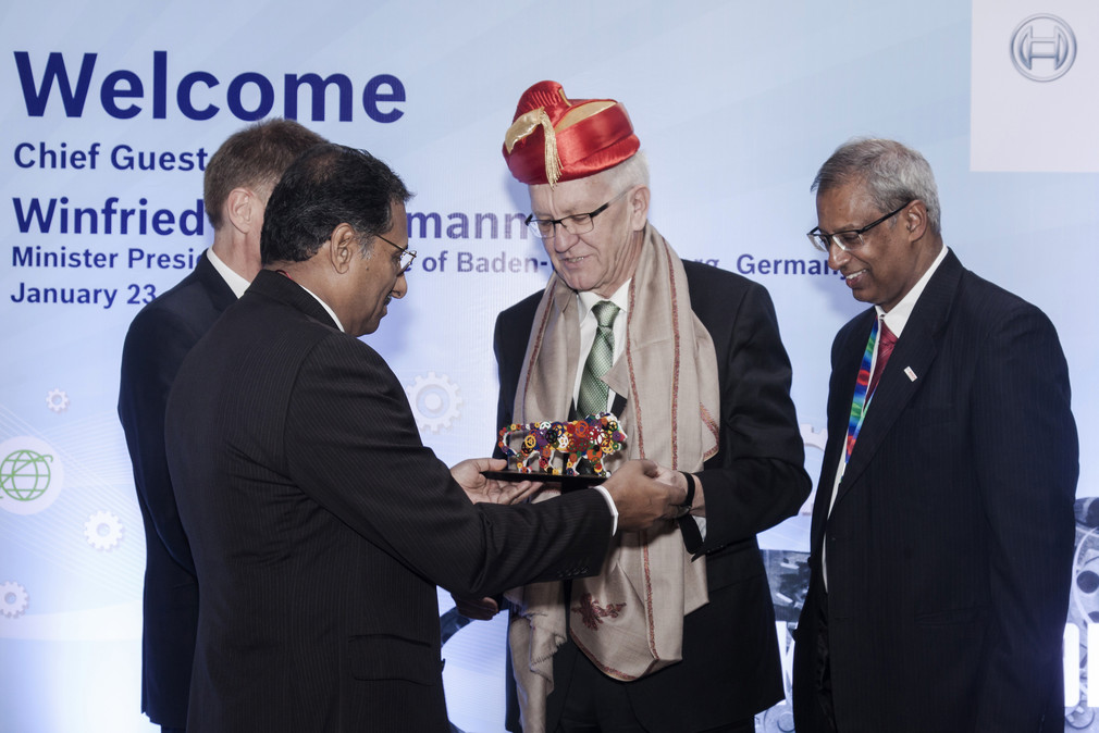 Ministerpräsident Winfried Kretschmann (M.) erhält bei Bosch India in Pune zur Begrüßung die traditionelle Kopfbedeckung „Pagarhi“ und ein Gastgeschenk.