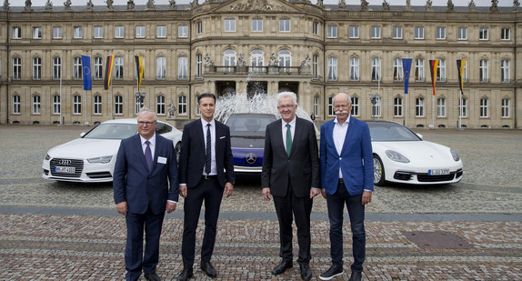 v.l.n.r.: Prof. Dr. Hubert Waltl (AUDI AG), Lutz Meschke (Porsche AG), Ministerpräsident Winfried Kretschmann und Dr. Dieter Zetsche (Daimler AG) stehen im Ehrenhof des Neuen Schlosses vor Elektrofahrzeugen.