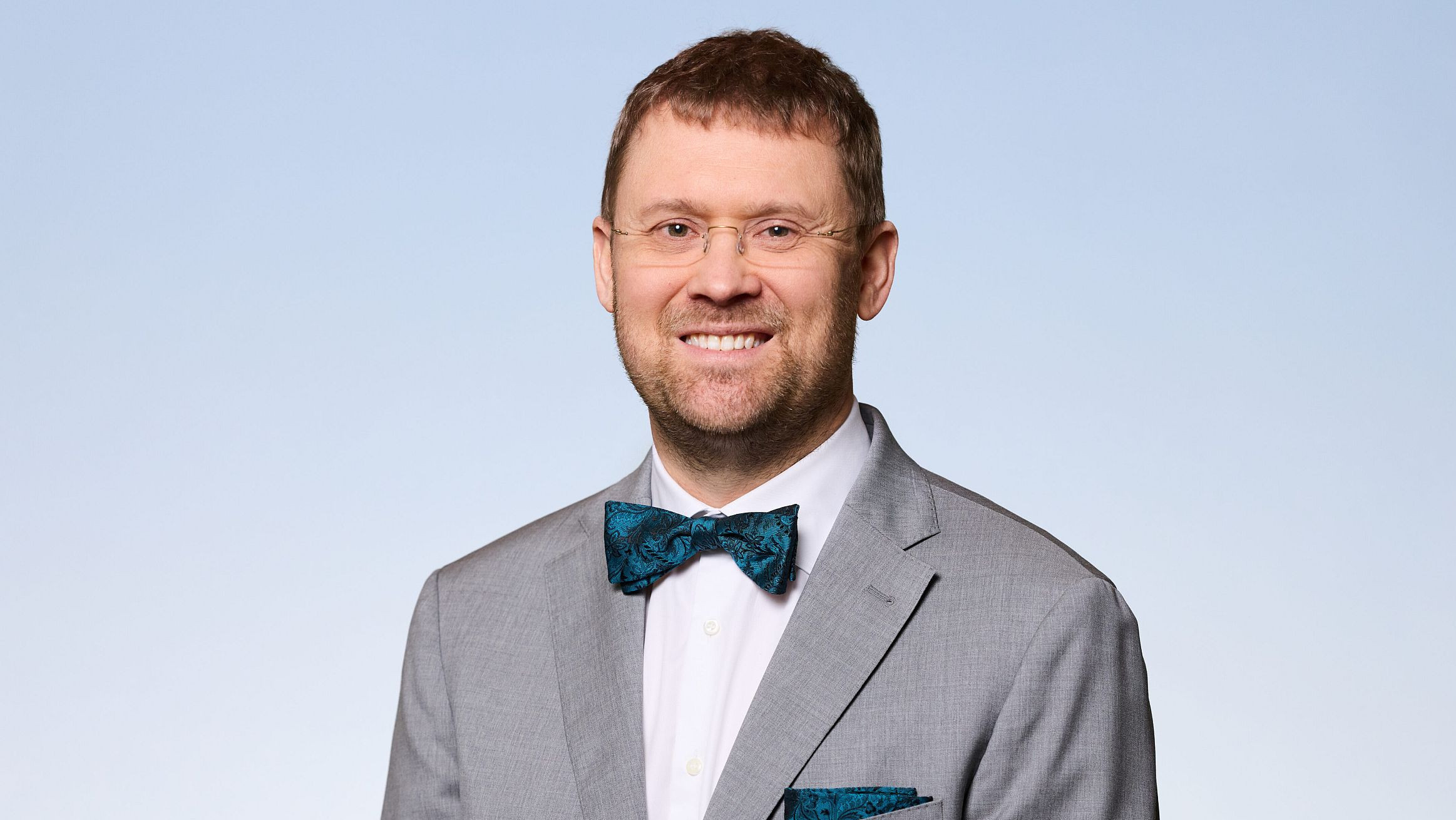 Mann in Anzug vor blauem Hintergrund