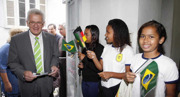Ministerpräsident Winfried Kretschmann wird von Schülerinnen und Schülern der Hafenschule „Escola Padre Motta“ in Rio de Janeiro begrüßt. (Foto: Uli Regenscheit Fotografie)