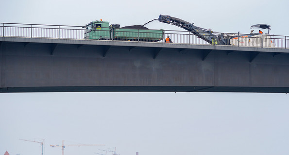 Ein Baufahrzeug hobelt auf der Salierbrücke in Speyer den Asphalt ab. Die Brücke, eine wichtige Verkehrsverbindung zwischen Rheinland-Pfalz und Baden-Württemberg, ist wegen Modernisierungsarbeiten für mehr als zwei Jahre gesperrt.