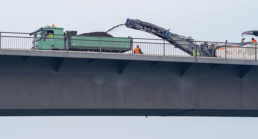 Ein Baufahrzeug hobelt auf der Salierbrücke in Speyer den Asphalt ab. Die Brücke, eine wichtige Verkehrsverbindung zwischen Rheinland-Pfalz und Baden-Württemberg, ist wegen Modernisierungsarbeiten für mehr als zwei Jahre gesperrt.