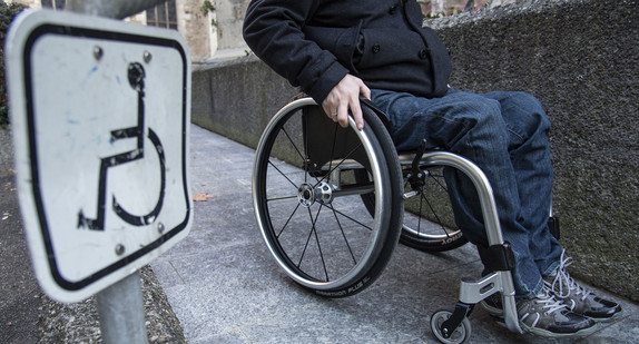 Ein Rollstuhlfahrer fährt eine Rampe hinab. (Foto: dpa)