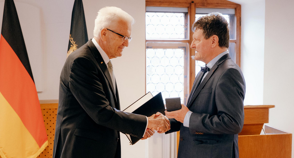 Ministerpräsident Winfried Kretschmann (links) überreicht Dr. Edwin Ernst Weber (rechts) die Staufermedaille des Landes Baden-Württemberg.