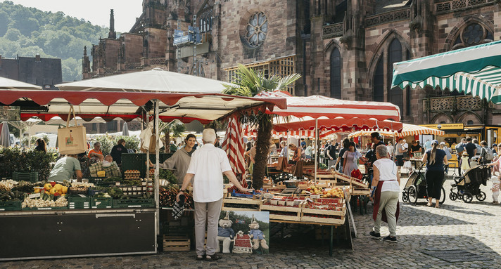 Menschen auf dem Wochenmarkt.