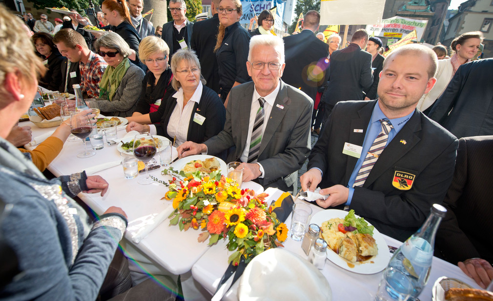 Ministerpräsident Winfried Kretschmann (M.) beim gemeinsamen Maultaschenessen mit Bürgerdelegationen