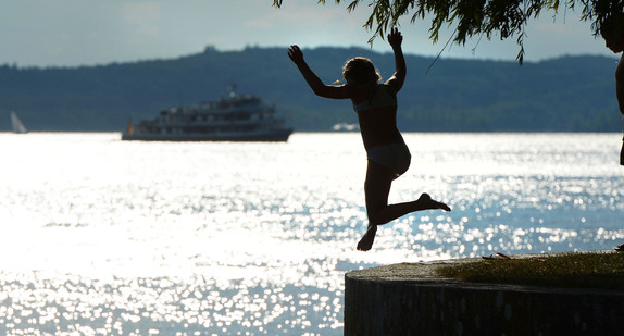 FEin Mädchen springt zur Abkühlung von der Meersburger Uferpromenade aus in den Bodensee (Bild: © dpa).
